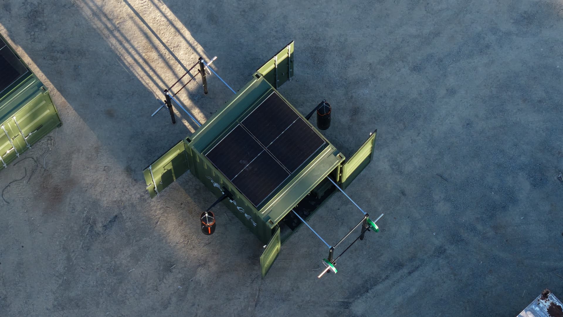 Aerial view of a deployed Forces Fitness Rapid unit with doors open, solar panels and external training rigs set up on site
