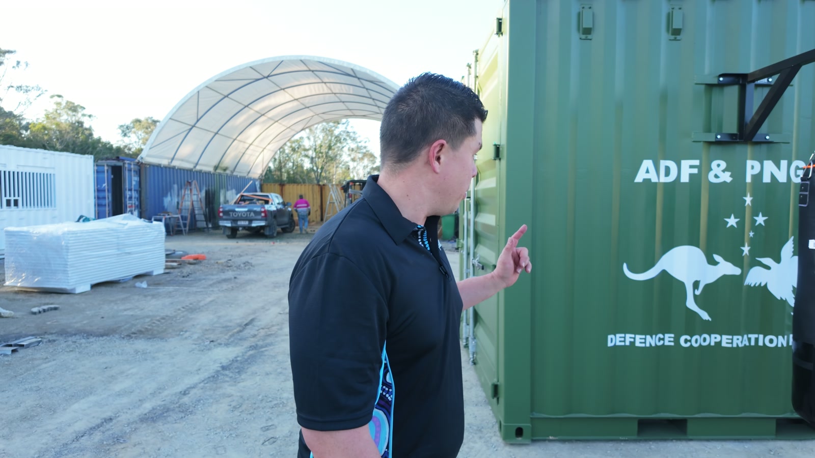 Founder beside the green Rapid-10 exterior with ADF and PNG defence cooperation branding in the demonstration yard